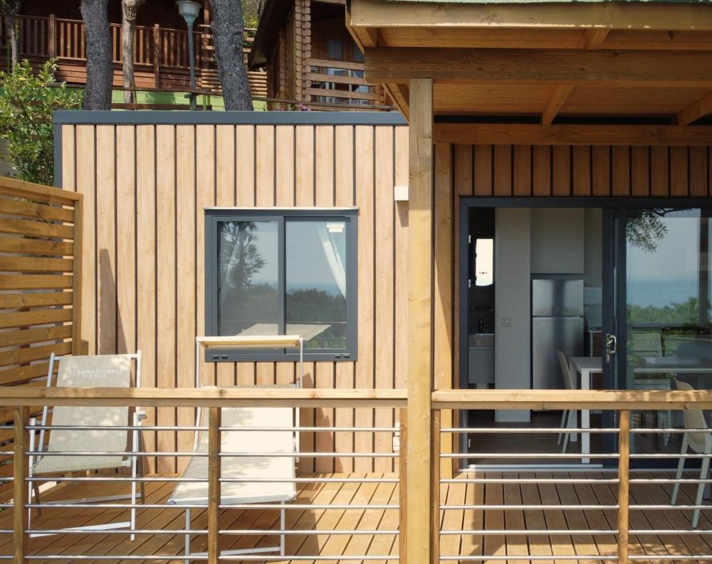 Gemütliches Holzbungalow mit Veranda, in der Natur eingebettet.