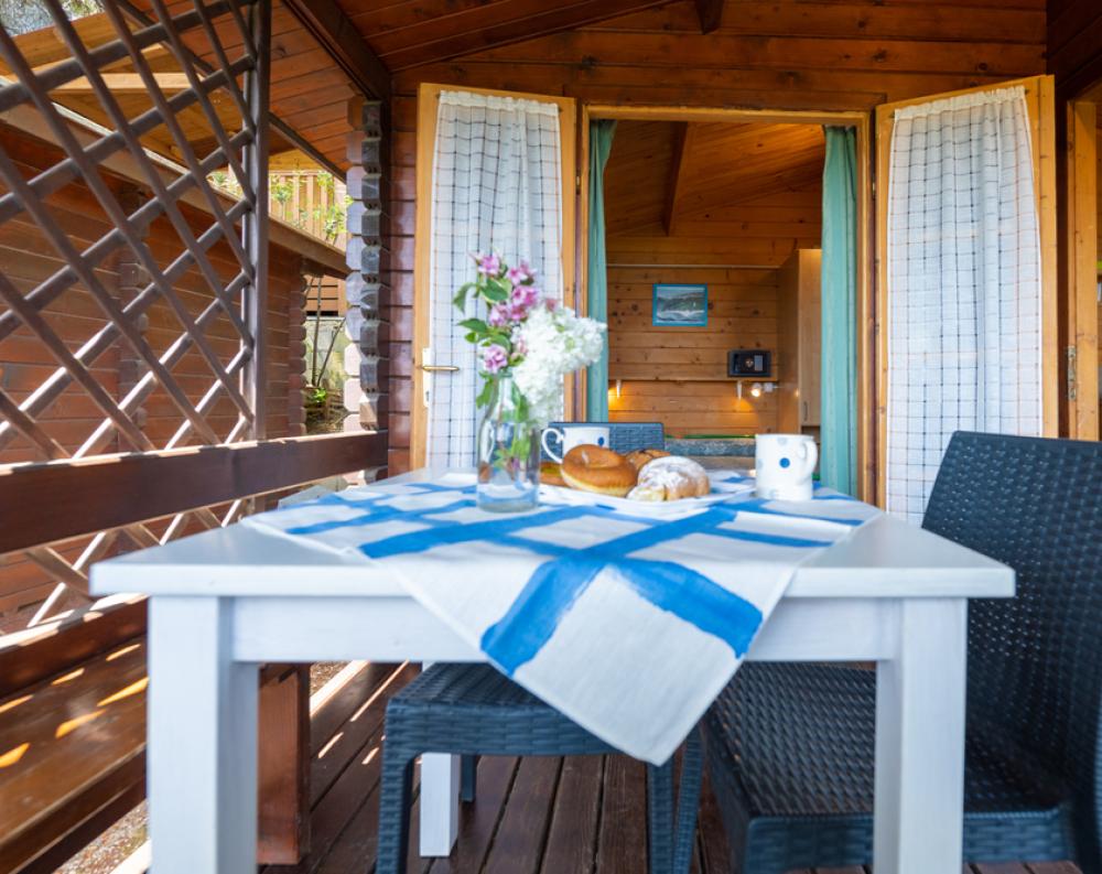 Cozy wooden porch with a breakfast set table.
