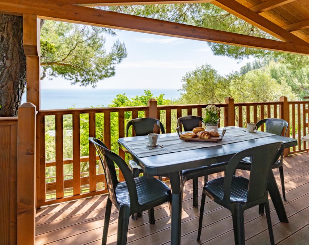 Wooden terrace with sea view, relaxing breakfast among trees and nature.