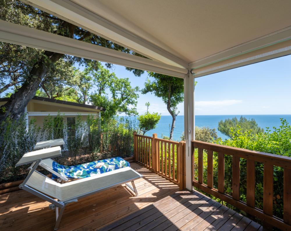 Sunny terrace with sea view, relaxation amid nature and blue sky.